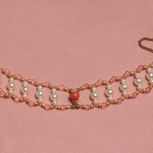 Collier ras le cou en perles vintage. 2 rangées de perles rose reliées entre elles par des petites rangées de 3 perles verticales blanches nacrées. Au centre il y a un pendentif doré orné d'une perle rose. Taille ajustable grâce à la chaînette dorée