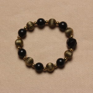 Bracelet vintage: alternance de perles noire et dorée avec des rainures. Petites perles dorées entre chaque perle