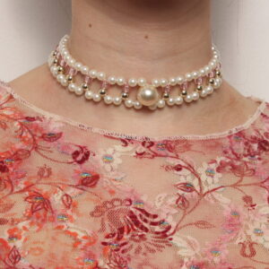 Ras le cou vintage en perles blanches nacrées, rose pâles et dorées. 2 rangées de perles blanches nacrées reliées entre elles par de petites colonnes de 2 perles une dorée et une rose pâle. Au centre, une plus grosse perle blanche nacrée rehausse le collier. Taille ajustable grâce à la chaînette.