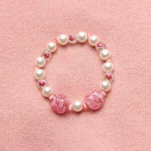 Bracelet en perles de verre alternant les perles blanches nacrées, celles avec un motif fleur et rehaussé de 2 perles rose pâles en verre de Murano