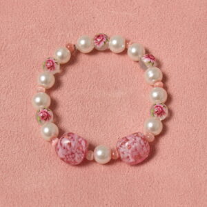 Bracelet en perles de verre alternant les perles blanches nacrées, celles avec un motif fleur et rehaussé de 2 perles rose pâles en verre de Murano