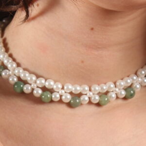 Le collier est un ras de cou composé de 2 rangées de perles de verre. La plus proche du cou est créée avec des perles blanches et la seconde avec une alternance de perles blanches et vertes. Chaînette d'extension à l'arrière.