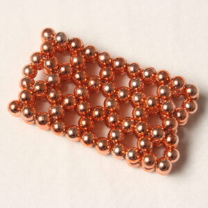Bracelet composé de 7 rangées de perles orange cuivrées. Toutes les perles sont identiques. Elles sont enfilées en quinconce.