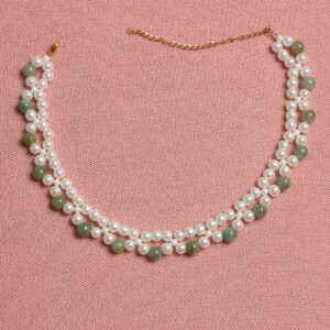 Le collier est un ras de cou composé de 2 rangées de perles de verre. La plus proche du cou est créée avec des perles blanches et la seconde avec une alternance de perles blanches et vertes. Chaînette d'extension à l'arrière.