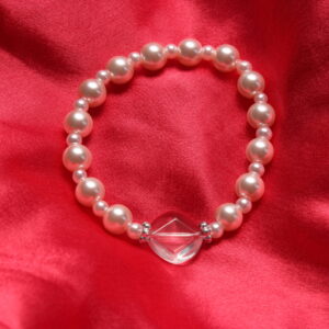 Ce bracelet est composé de perles en verre roses pâles et au centre d'une magnifique perle transparente en verre en forme de losange entourée de 2 intercalaires argentés.