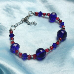 Ce bracelet est constitué de perles en verre à facette bleues, des perles rondes en verre bleues nuit et des petites perles à facette roses. Il y a également des petites intercalaires argentées. Le bracelet se ferme grâce à un fermoir et une chaînette.